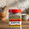 A jar of Village Kafta spices with a red lid, labeled 'KAFTA' in bold yellow and red lettering, against a white background.