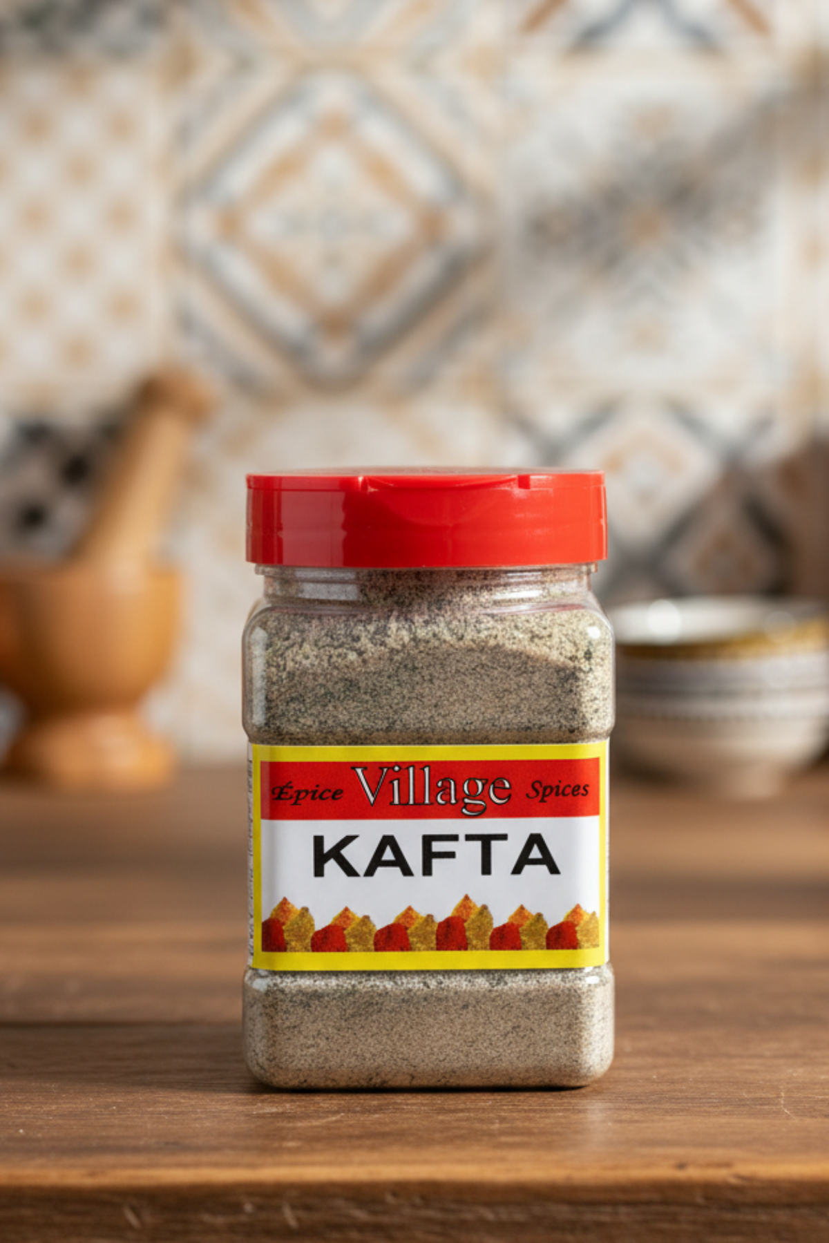 A jar of Village Kafta spices with a red lid, labeled 'KAFTA' in bold yellow and red lettering, against a white background.