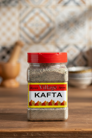 A jar of Village Kafta spices with a red lid, labeled 'KAFTA' in bold yellow and red lettering, against a white background.