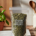 A clear plastic packaging containing raw pumpkin seeds, with the brand 'Dandy' labeled on the top.