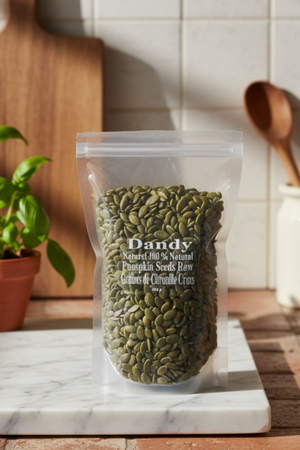 A clear plastic packaging containing raw pumpkin seeds, with the brand 'Dandy' labeled on the top.
