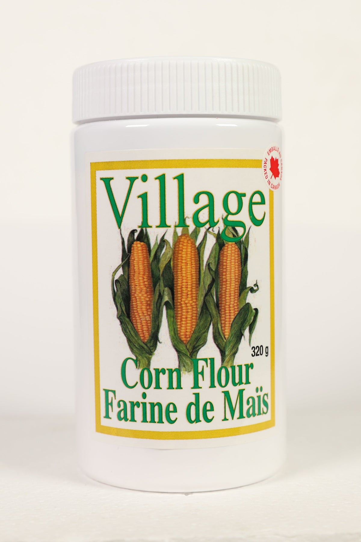A container of Village brand corn flour, labeled 'Corn Flour' and 'Farine de Mais' with a net weight of 320 grams.